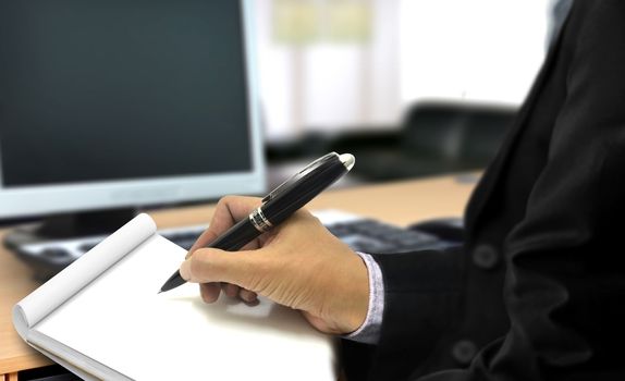 Man writing on notepad in the office