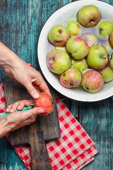 Man washes and cleans the autumn apple harvest