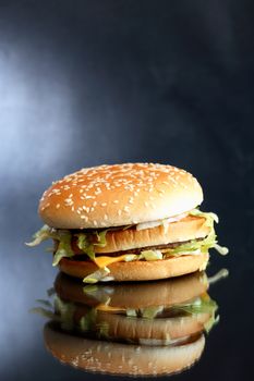 Closeup of hamburger on dark background with reflection