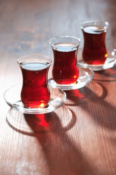 Three cups of Turkish tea in a row on wooden table