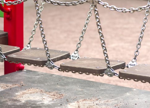 bridge on the chains of the wooden planks on the playground