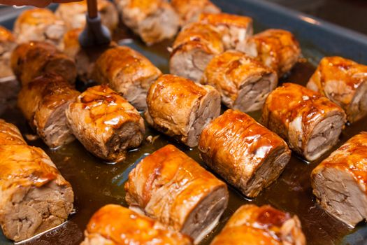 meat rolls on metallic platter in oven