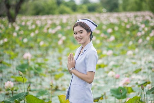 Portrait of a Beautiful Young Woman Asian Nurse in the Lotus Park