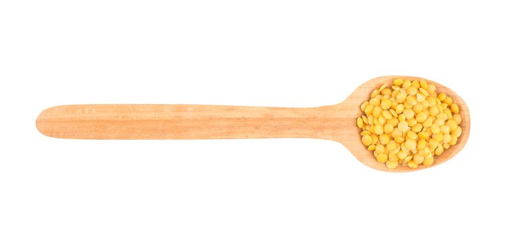 Yellow lentil in a wooden spoon