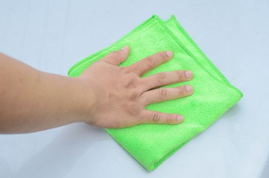 A man cleaning car with green microfiber cloth