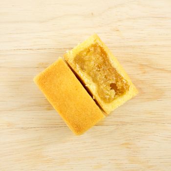 The tasty Taiwanese pineapple pastry cake with egg yolk on the wooden plank.