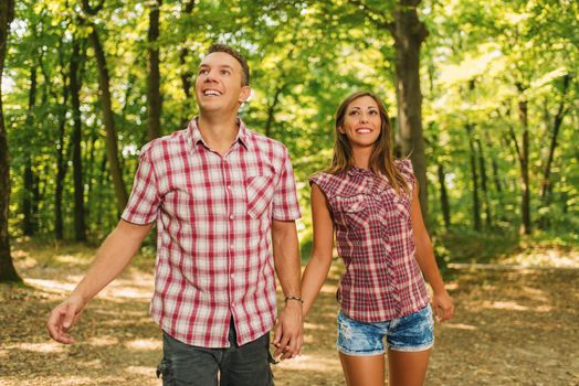 Beautiful young couple enjoying a walk in the forest.