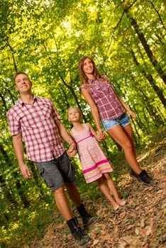 Beautiful young family enjoying a walk in the forest.