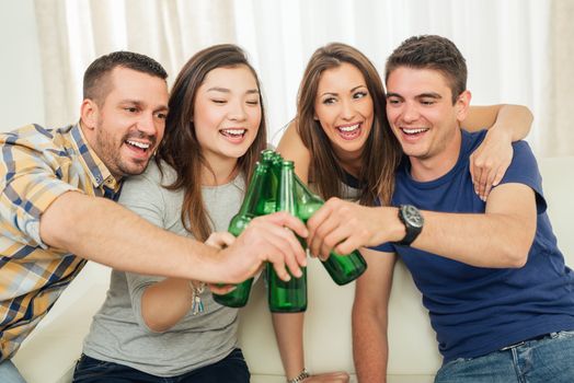 Friends enjoying with beer and cheers together at home party.