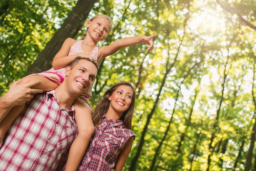 Beautiful young family enjoying a walk in the forest.