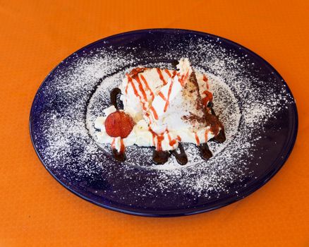 Meringue with fresh strawberry and cacao on blue plate.