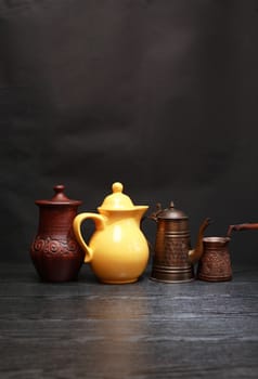 Set of various kitchen dishes on dark background