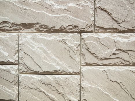 a wall from an artificial gray stone facade with rough fractured surfaces