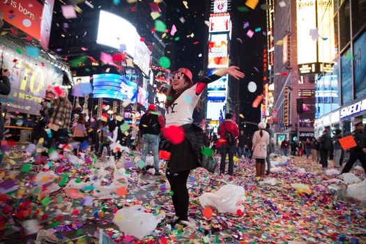 UNITED STATES, New York: A woman gestures through the debris of celebrating new years after ringing in the new year in Times Square on January 1, 2016 in New York City. The New York Police Department will have more than 6,000 officers in the Times Square area, including more than 1,100 officers who graduated from the police academy on Tuesday. It will be the largest such deployment of police in New York City ever. 