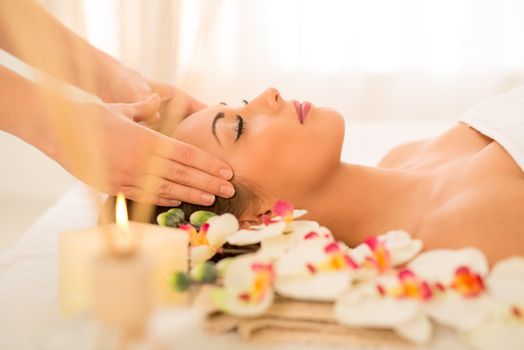 Cute young woman enjoying in head massage with her eyes closed.