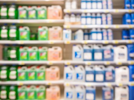 Blurred colorful motor oil bottles on shelves in supermarket as background