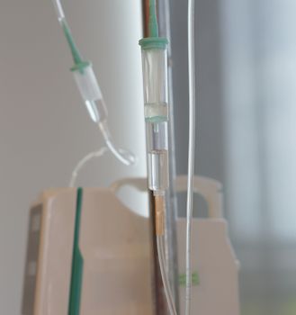 Automatic infusion pump and saline IV solution dropper in hospital.