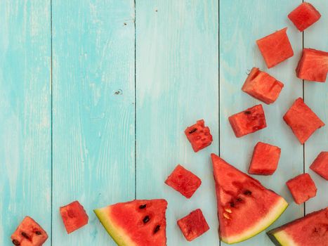 Top view of watermelon pieces on blue wooden table with copyspace. Flat lay