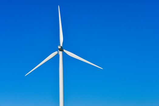 Windmills for electric power production on blue sky, France, Europe