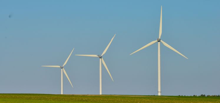 Windmills for electric power production on blue sky, France, Europe