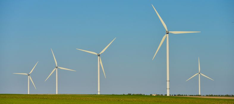 Windmills for electric power production on blue sky, France, Europe
