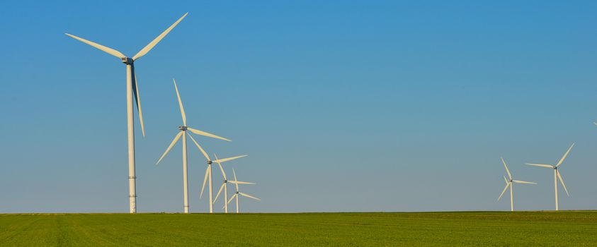 Windmills for electric power production on blue sky, France, Europe