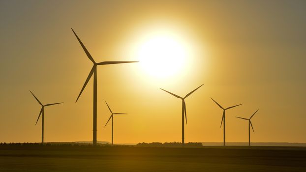 Windwheels and a beautiful sunset seen in rural France, Europe