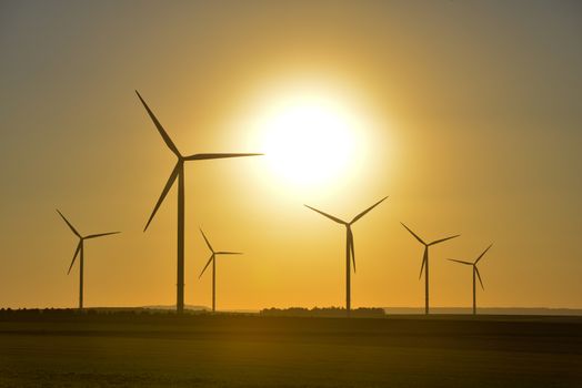 Windwheels and a beautiful sunset seen in rural France, Europe