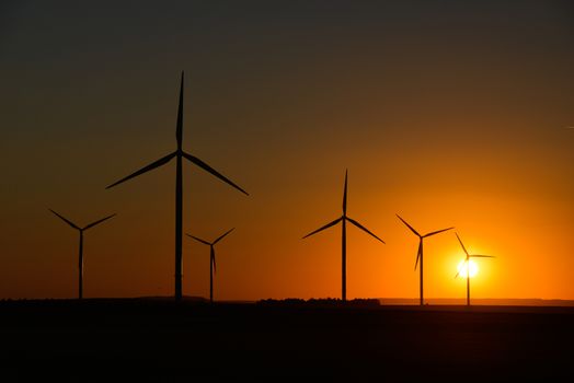 Windwheels and a beautiful sunset seen in rural France, Europe