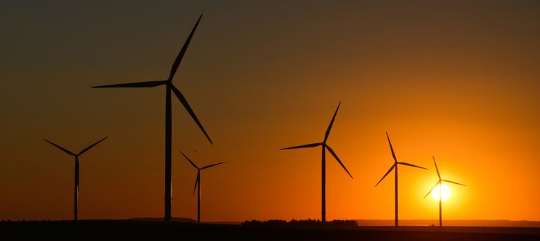 Windwheels and a beautiful sunset seen in rural France, Europe