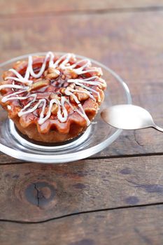 Closeup of cake on glass saucer on nice wooden background