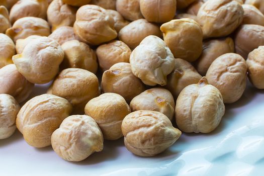 Chickpeas Close Up. Pile of Organic Uncooked Chickpeas. Gold Chickpeas Background. Healthy Vegan Food Hummus With Chickpeas. Selective Focus and Shallow Depth of Field.