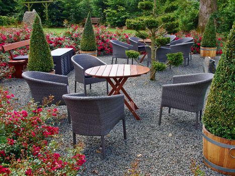 Landscaped backyard with beautiful garden furniture tables and chairs in lush green area