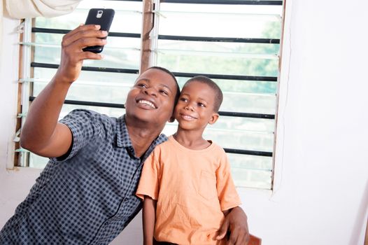 Father and son are very happy to take pictures with his mobile phone.