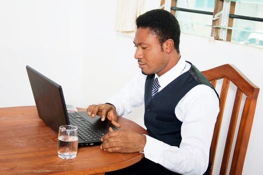 Young businessman sitting in his office and working on his laptop.