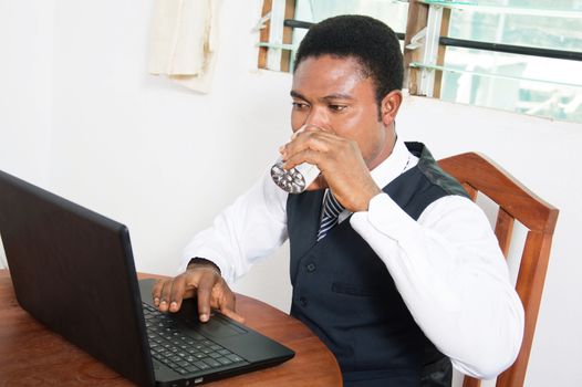 Too thirsty young businessman is drinking.