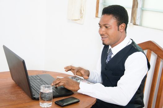The businessman in front of his laptop, performs calculation on his calculator