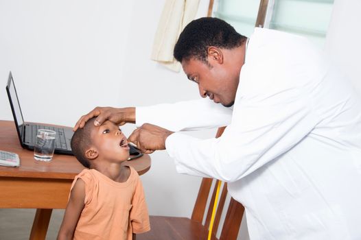 The health professional examines the boy looking in his mouth.