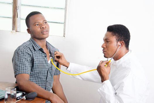 The doctor is listening to the heartbeat of his patient.