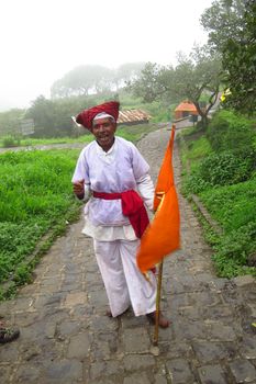 An elderly person dressed as an ancient hindu warrior called as the Mawla on Sinhagad fort.