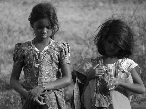 Poor Indian girls lost in their thoughts on a hot summer afternoon.