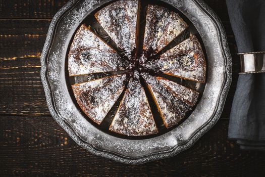 Sliced cake with icing sugar and jam  and napkin in the vintage ring