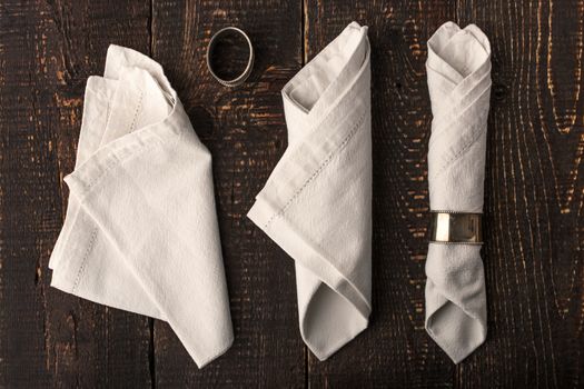 Set of the napkins with vintage ring on the wooden table top view