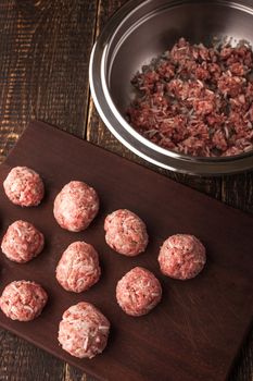 Meatballs on the wooden board with stuffing in a pan top view vertical