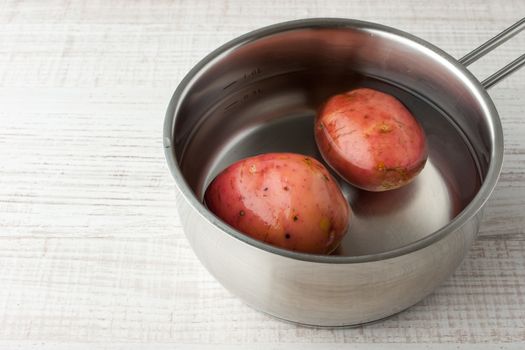 Potatoes in water in a metal pan horizontal