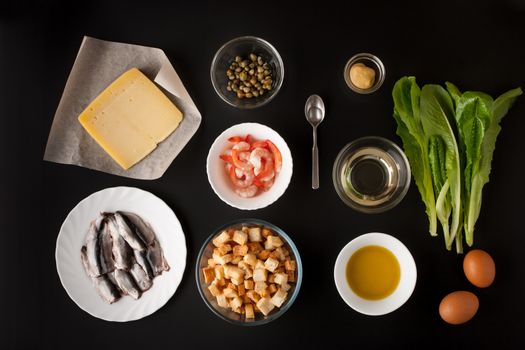 Ingredients for Caesar salad on the black background horizontal