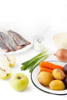 Ingredients for vegetable salad with apple and fish  on the white background vertical