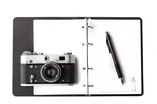Open clear notebook with pen and camera