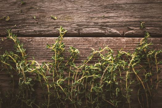 Thyme sprigs on the old wooden board top view