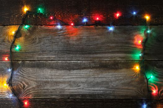 Frame of the colorful Christmas festoon on the wooden board